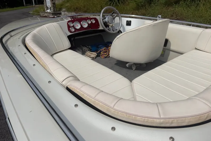 Slide: The Image of Interior of a 1990 Donzi Sweet 16 boat with white seating and dashboard. - 11