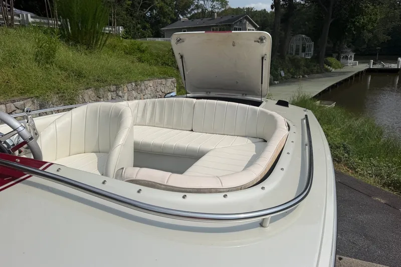 Slide: The Image of 1990 Donzi Sweet 16 boat with white interior, docked by a serene lakeside. - 12