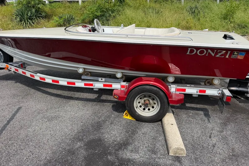 Slide: The Image of 1990 Donzi Sweet 16 boat on trailer, red and white design, parked on asphalt. - 24
