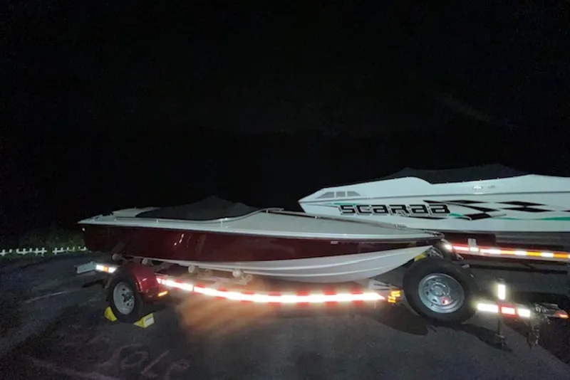 Slide: The Image of 1990 Donzi Sweet 16 boat on trailer at night, parked beside another boat. - 22
