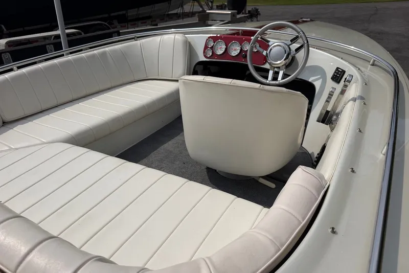 Slide: The Image of Interior of a 1990 Donzi Sweet 16 boat with white seating and red dashboard. - 7