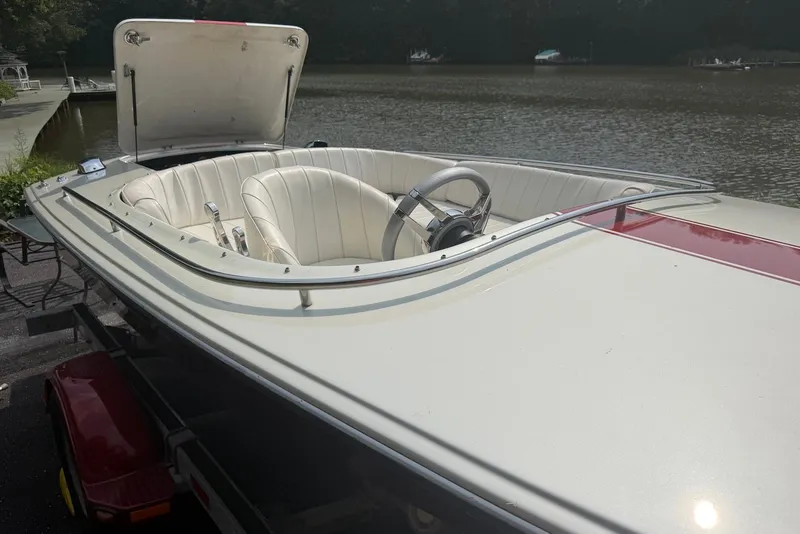 Slide: The Image of 1990 Donzi Sweet 16 boat with white interior, docked by a serene lake. - 4