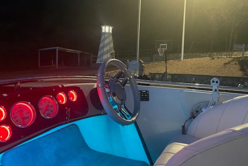 Slide: The Image of Interior of a 1990 Donzi Sweet 16 boat with illuminated dashboard gauges. - 10