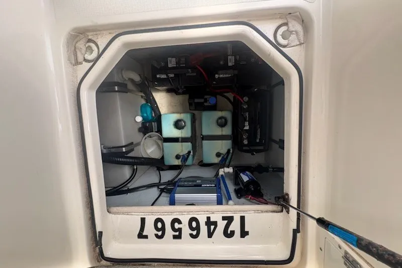 Slide: The Image of 1999 Pursuit 2870 Walkaround boat battery compartment with wiring and components. - 22