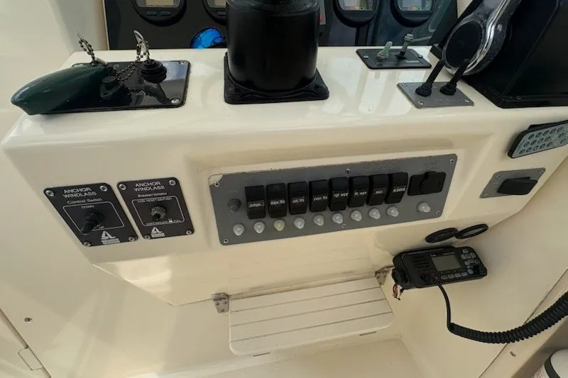 Slide: The Image of Control panel of a 1999 Pursuit 2870 Walkaround boat with switches and radio. - 21