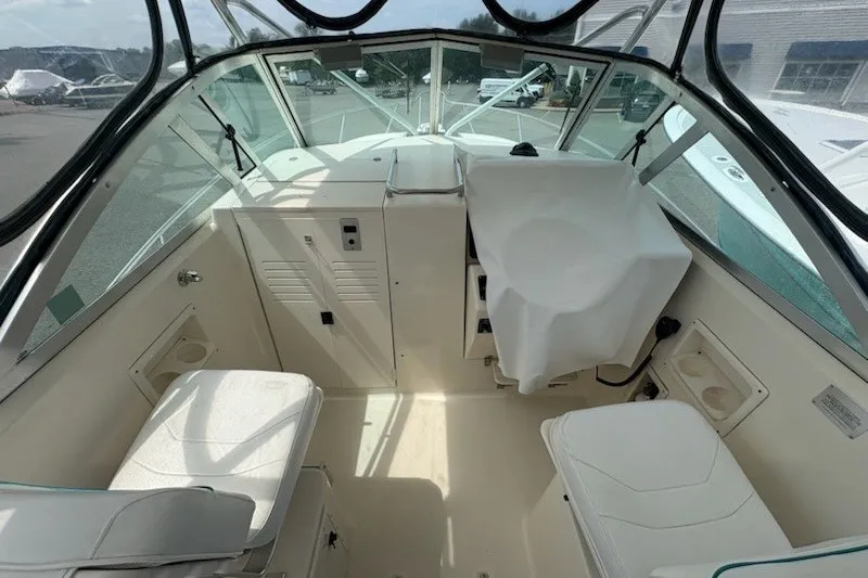Slide: The Image of 1999 Pursuit 2870 Walkaround boat interior with seating and covered controls. - 15