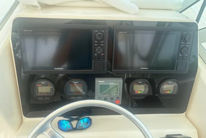 Slide: The Image of Dashboard of a 1999 Pursuit 2870 Walkaround boat with Garmin displays and gauges. - 18