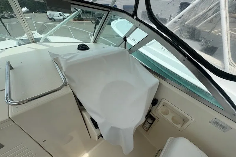 Slide: The Image of 1999 Pursuit 2870 Walkaround boat helm covered with white fabric. - 13