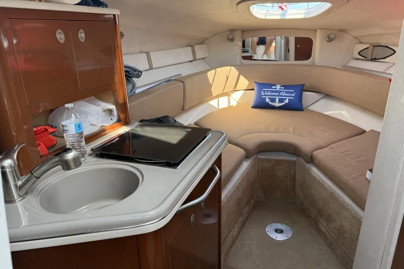 Slide: The Image of Interior of 2009 Sea Ray 230 Sundancer with kitchenette and cozy seating area. - 7