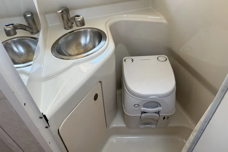 Slide: The Image of Compact bathroom in 2009 Sea Ray 230 Sundancer with sink and portable toilet. - 11