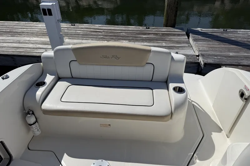Slide: The Image of 2009 Sea Ray 230 Sundancer boat seating area with cup holders and dock view. - 6