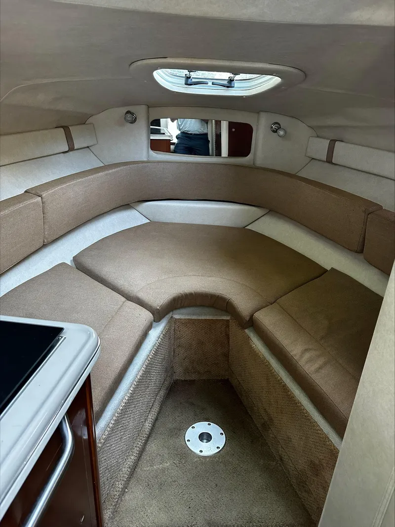 Slide: The Image of Interior of a 2009 Sea Ray 230 Sundancer with cushioned seating areas and a skylight. - 9