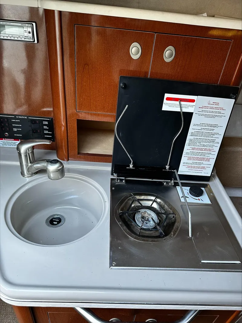 Slide: The Image of The galley of a 2009 Sea Ray 230 Sundancer with a sink and stove. - 8