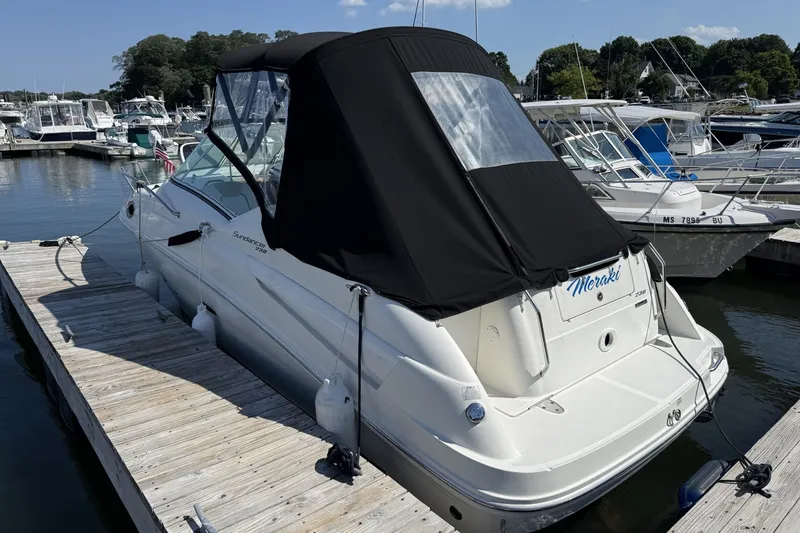 The Image of 2009 Sea Ray 230 Sundancer docked at marina, featuring black canopy and sleek design. - 0