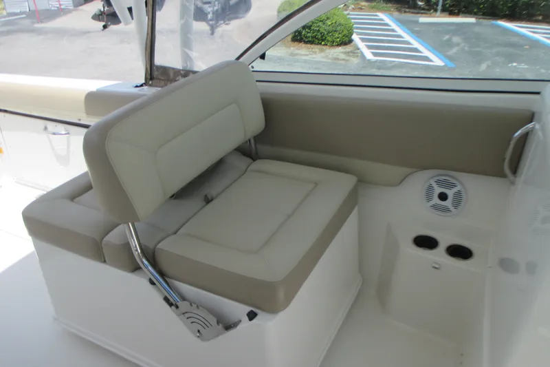 Slide: The Image of 2017 Sailfish 275 DC boat interior with beige seating and cup holders. - 19