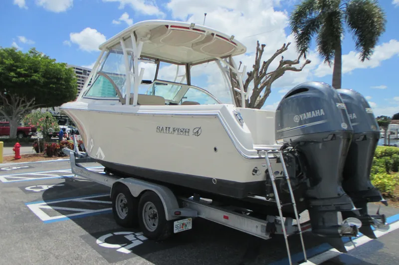 Slide: The Image of 2017 Sailfish 275 DC boat on trailer with twin Yamaha engines, parked outdoors. - 9
