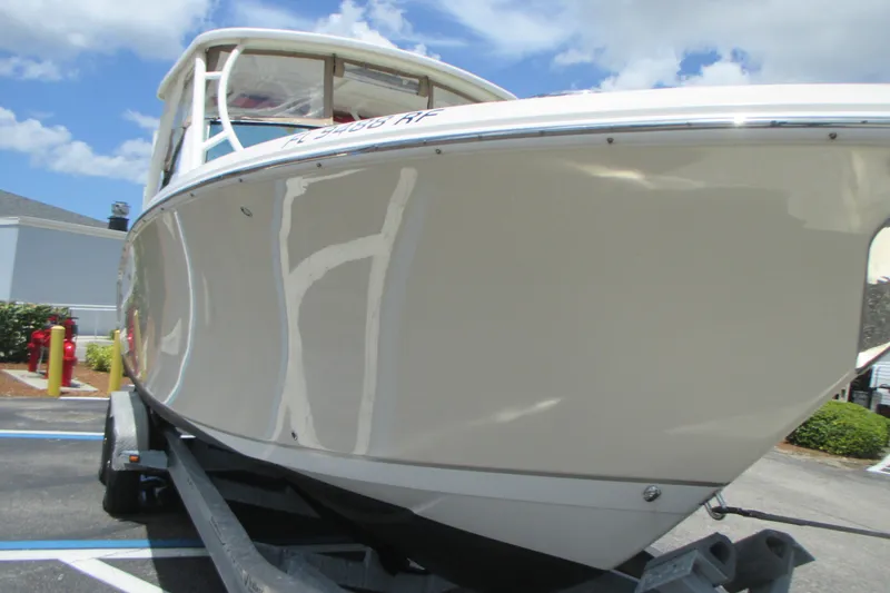 Slide: The Image of 2017 Sailfish 275 DC boat on trailer under a clear blue sky. - 5