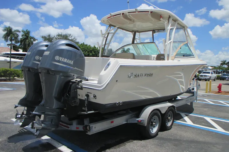 Slide: The Image of 2017 Sailfish 275 DC boat on trailer with twin Yamaha engines, parked outdoors. - 8