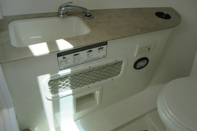 Slide: The Image of Interior of 2017 Sailfish 275 DC boat featuring sink, faucet, and storage compartment. - 29