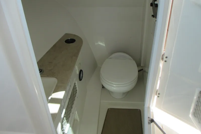 Slide: The Image of Interior of 2017 Sailfish 275 DC boat bathroom with toilet and sink. - 28