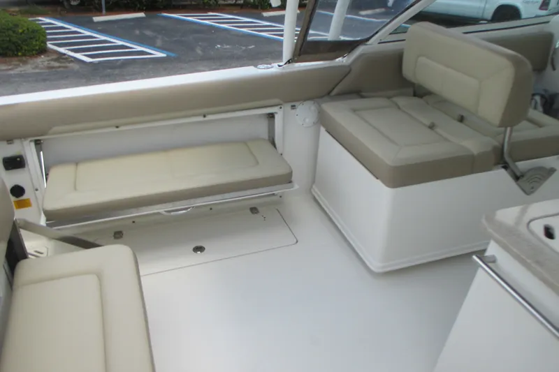 Slide: The Image of Interior of a 2017 Sailfish 275 DC boat featuring beige cushioned seating. - 17