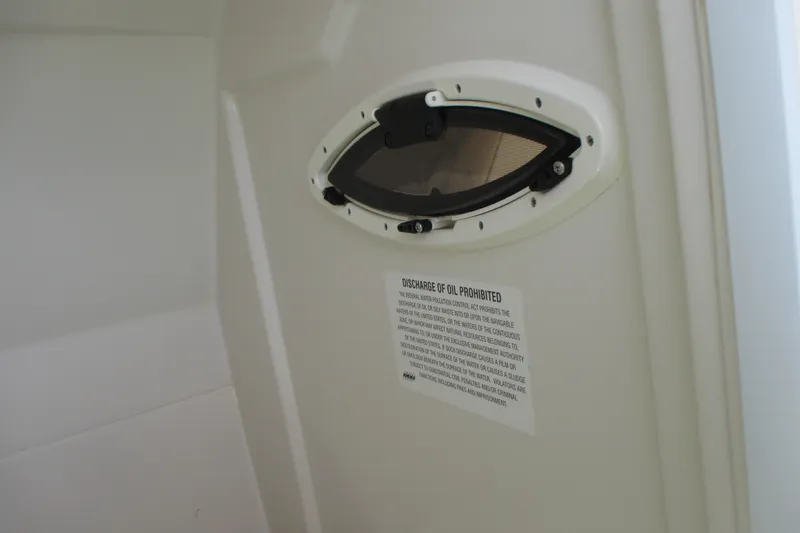 Slide: The Image of 2017 Sailfish 275 DC boat interior with oval window and oil discharge warning sign. - 30