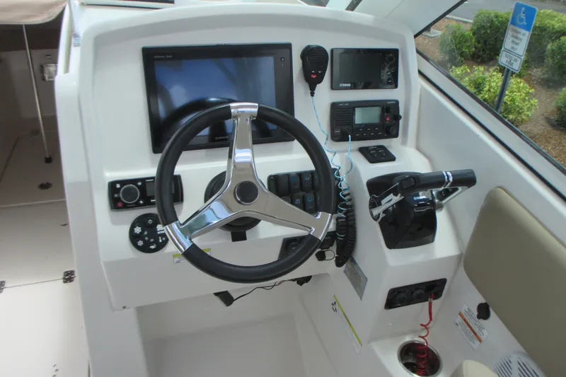 Slide: The Image of 2017 Sailfish 275 DC helm with steering wheel, controls, and navigation equipment. - 20