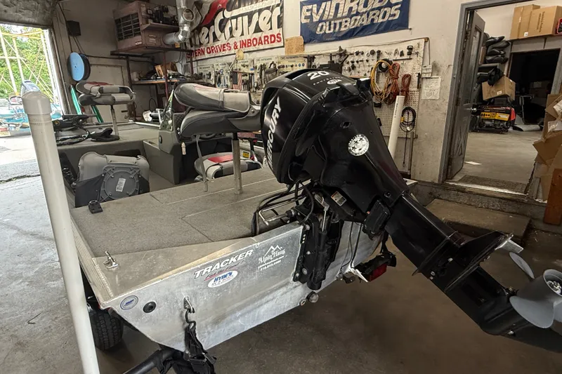 Slide: The Image of 2013 Bass Tracker Pro 16 boat in a workshop with Mercury outboard motor. - 13