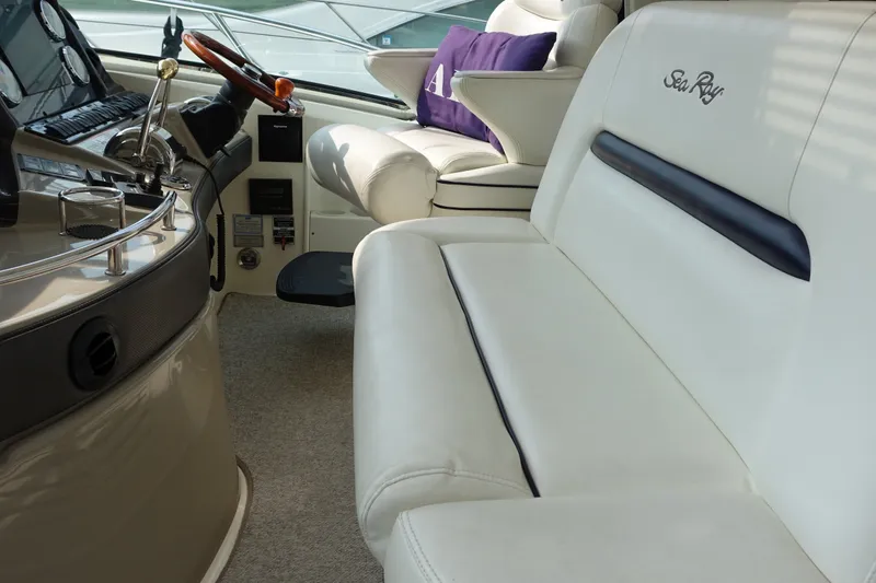 Slide: The Image of The image shows the cockpit of a 2006 Sea Ray 44 Sundancer with white leather seating. - 11