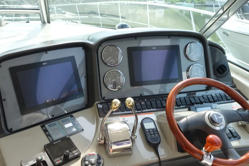 Slide: The Image of Control panel of a 2006 Sea Ray 44 Sundancer yacht with steering wheel and navigation screens. - 6