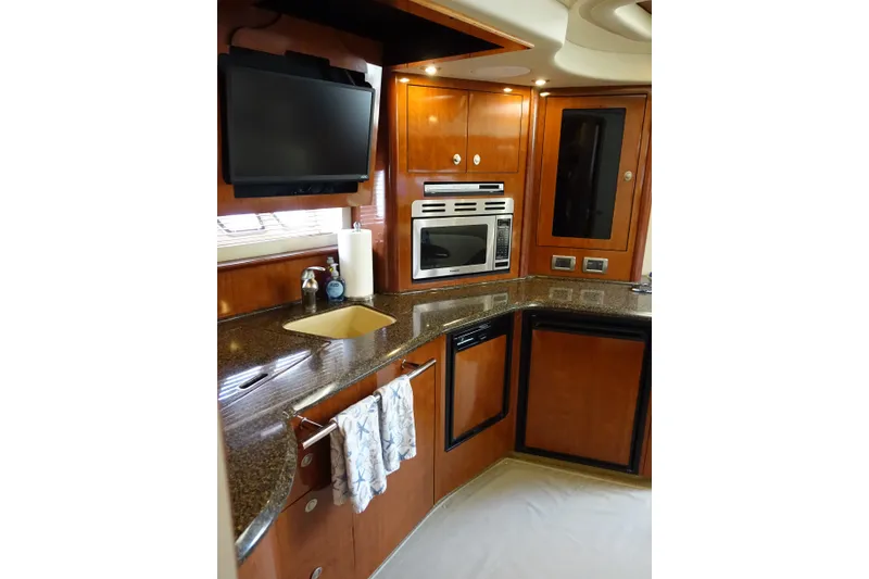 Slide: The Image of Luxurious 2006 Sea Ray 44 Sundancer yacht kitchen with modern appliances and elegant wood cabinetry. - 28