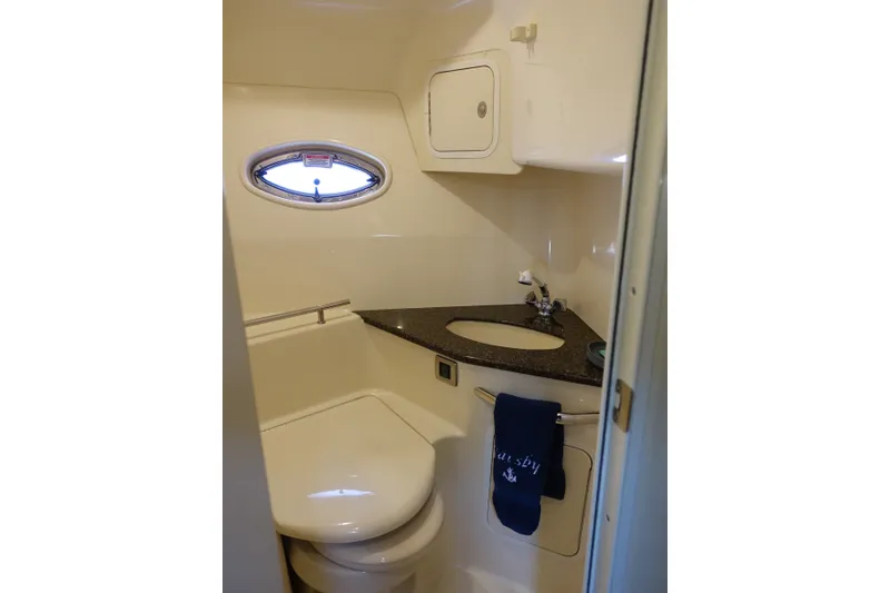 Slide: The Image of 2006 Sea Ray 44 Sundancer bathroom with oval window, sink, and toilet. - 34