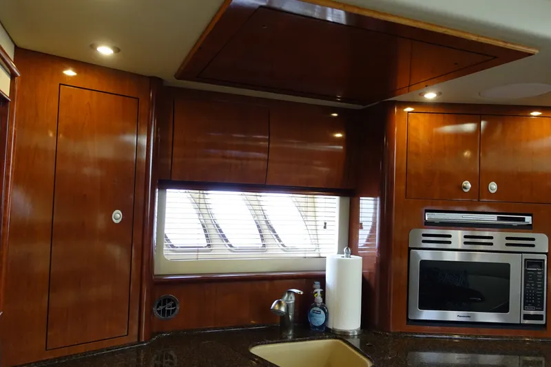 Slide: The Image of Luxurious 2006 Sea Ray 44 Sundancer yacht kitchen with wood cabinetry and modern appliances. - 25