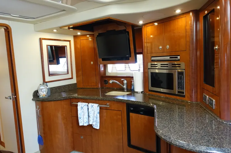 Slide: The Image of Luxurious 2006 Sea Ray 44 Sundancer yacht kitchen with wood cabinetry and modern appliances. - 26