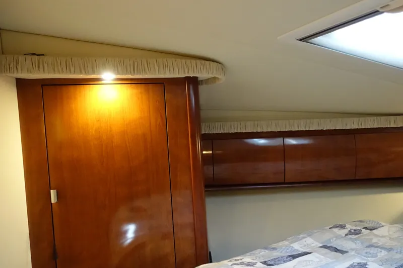 Slide: The Image of Luxurious 2006 Sea Ray 44 Sundancer cabin interior with wood finish and overhead lighting. - 42