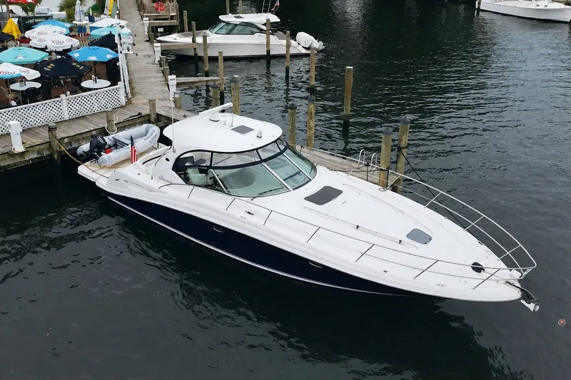Slide: The Image of 2006 Sea Ray 44 Sundancer yacht docked at marina near waterfront restaurant. - 4