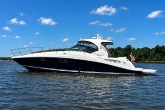 Slide: The Image of 2006 Sea Ray 44 Sundancer yacht on calm water under blue sky. - 1