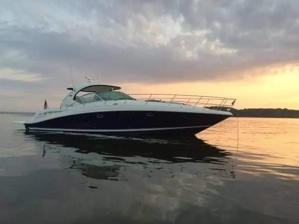 The Image of A 2006 Sea Ray 44 Sundancer sits calmly on the water at sunset. - 0