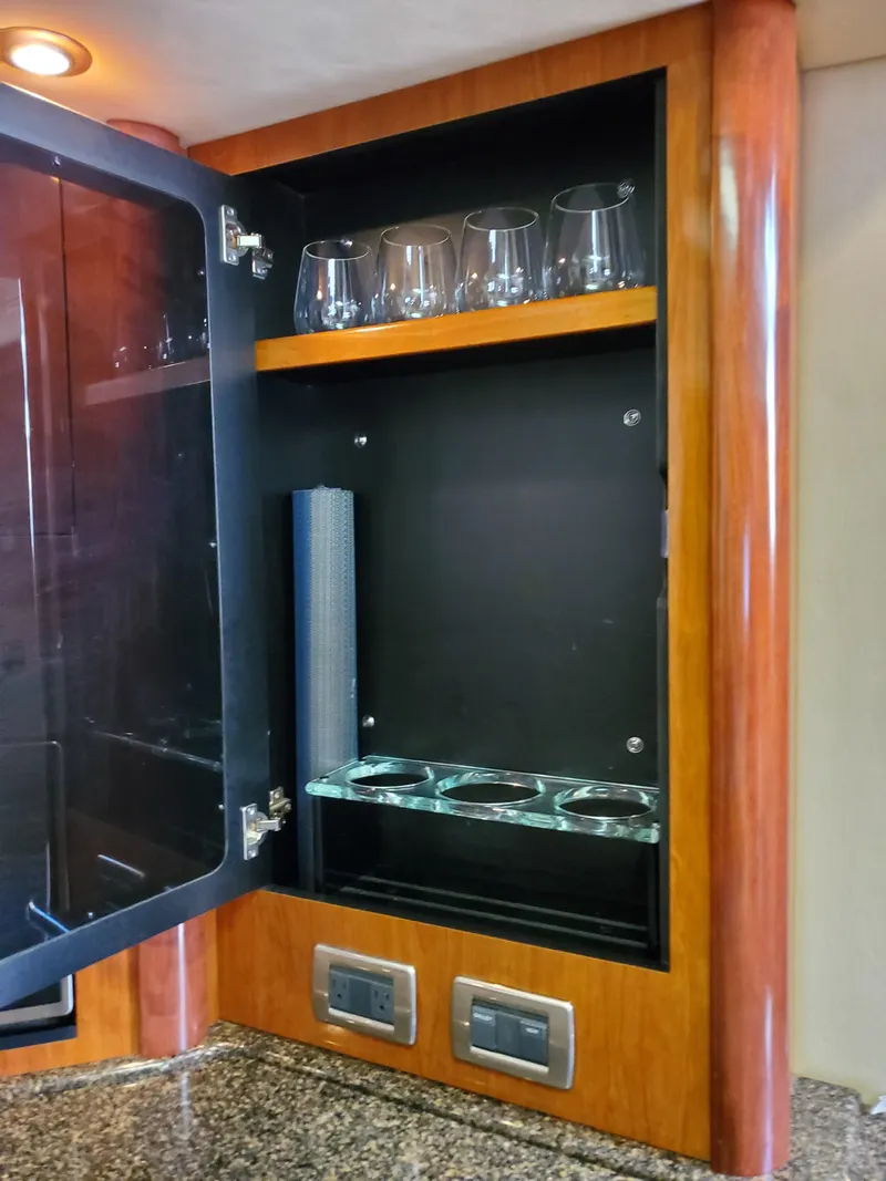 Slide: The Image of A sleek cabinet with glasses and shelves in a 2006 Sea Ray 44 Sundancer. - 31