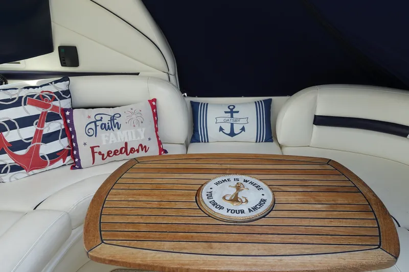 Slide: The Image of Interior of 2006 Sea Ray 44 Sundancer with nautical-themed cushions and wooden table. - 16