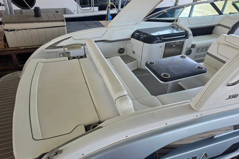 Slide: The Image of 2020 Formula 350 Crossover Bowrider OB interior with seating and table, docked at marina. - 13