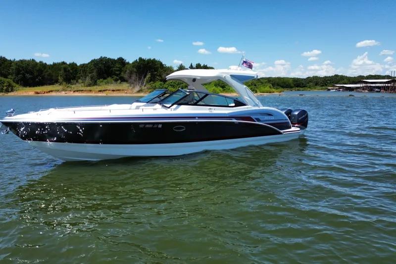 Slide: The Image of 2020 Formula 350 Crossover Bowrider OB on a sunny lake, surrounded by trees. - 2