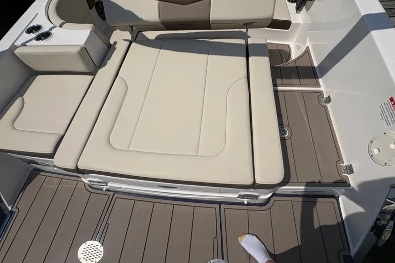 Slide: The Image of 2024 Chaparral 247 SSX boat interior with beige seating and brown flooring. - 18