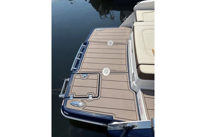 Slide: The Image of 2024 Chaparral 247 SSX boat swim platform with beige decking and stainless steel accents. - 23