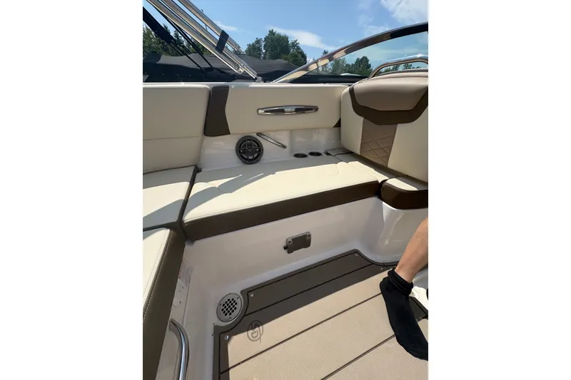 Slide: The Image of 2024 Chaparral 247 SSX boat interior with beige and brown seating, speaker, and cup holders. - 15