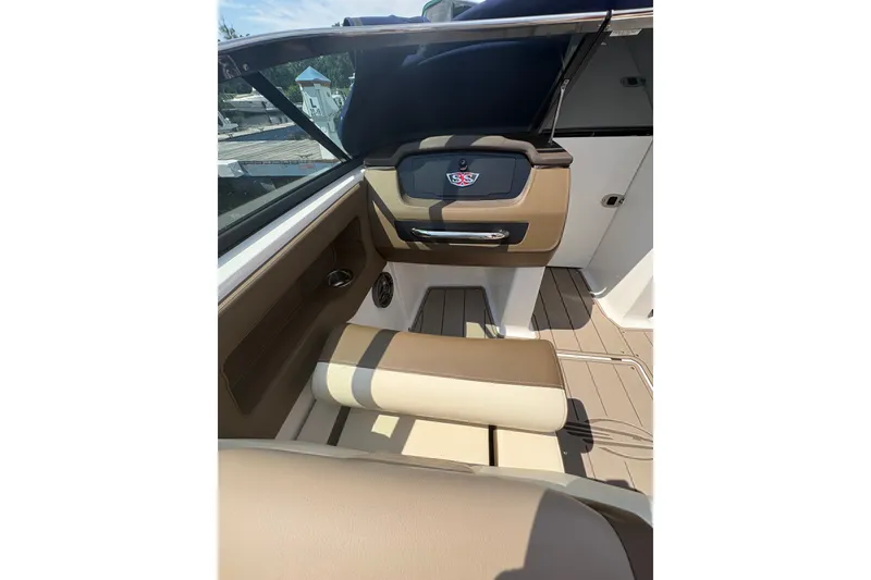 Slide: The Image of 2024 Chaparral 247 SSX boat interior with tan seating and sleek dashboard design. - 6