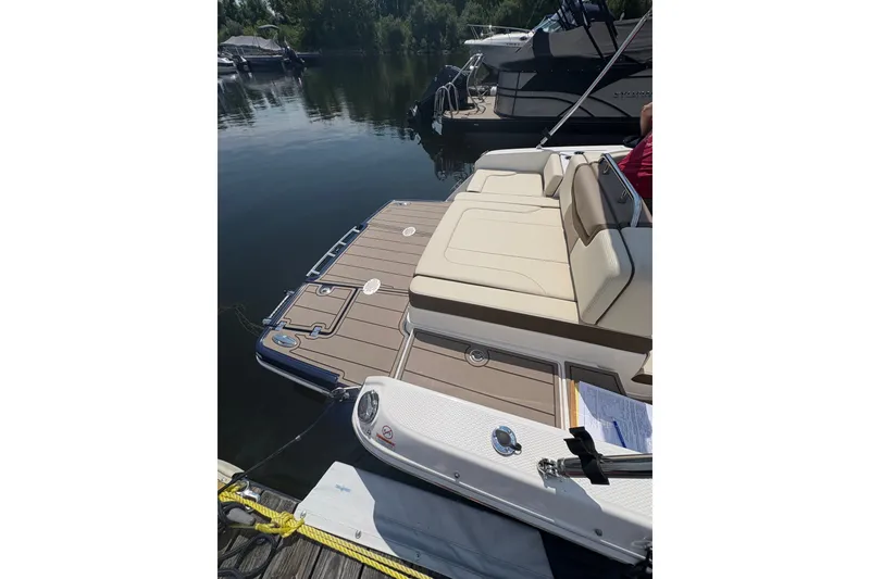 Slide: The Image of 2024 Chaparral 247 SSX boat docked, featuring a spacious swim platform and luxurious seating. - 20