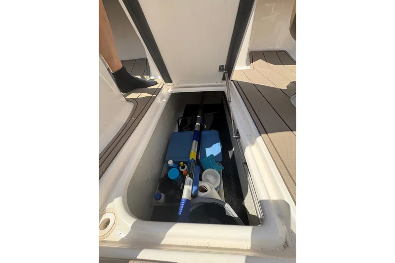 Slide: The Image of Storage compartment of 2024 Chaparral 247 SSX boat with cleaning supplies and equipment. - 8