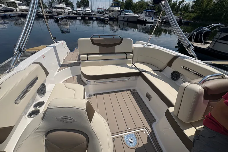 Slide: The Image of 2024 Chaparral 247 SSX boat interior with luxurious seating and modern design at a marina. - 14