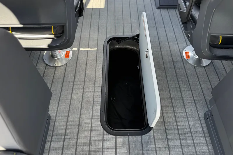 Slide: The Image of Open storage compartment on Manitou EXPLORE 24 boat, 2025 model, with gray flooring. - 24